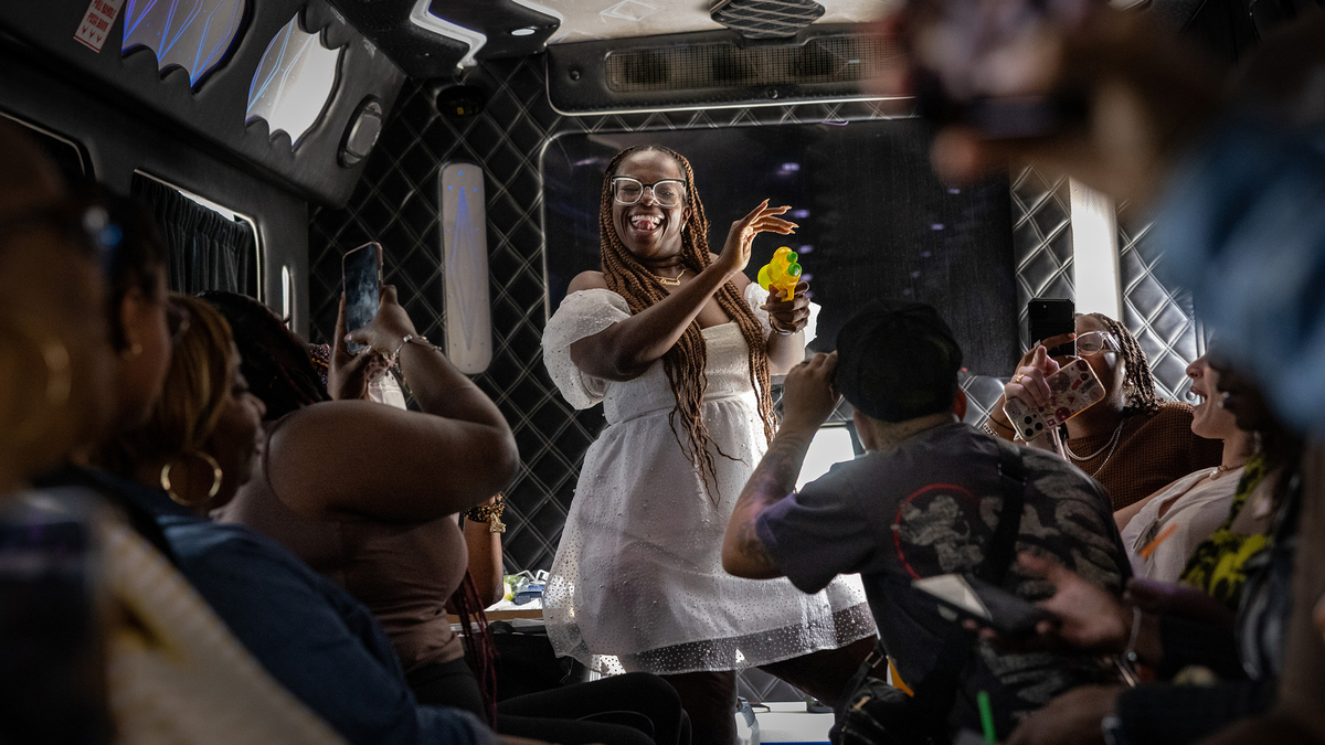 Daisy Miles, owner of the Daisy BLK LA Food Tour, spays our shots on the party bus as guest enjoy drinks, music, games and fellowship as they make their way on a tour that highlights L.A.'s Black-owned restaurants and food businesses on Saturday, Aug. 16, 2025, in Los Angeles, California. (Jason Armond/Los Angeles Times/TNS