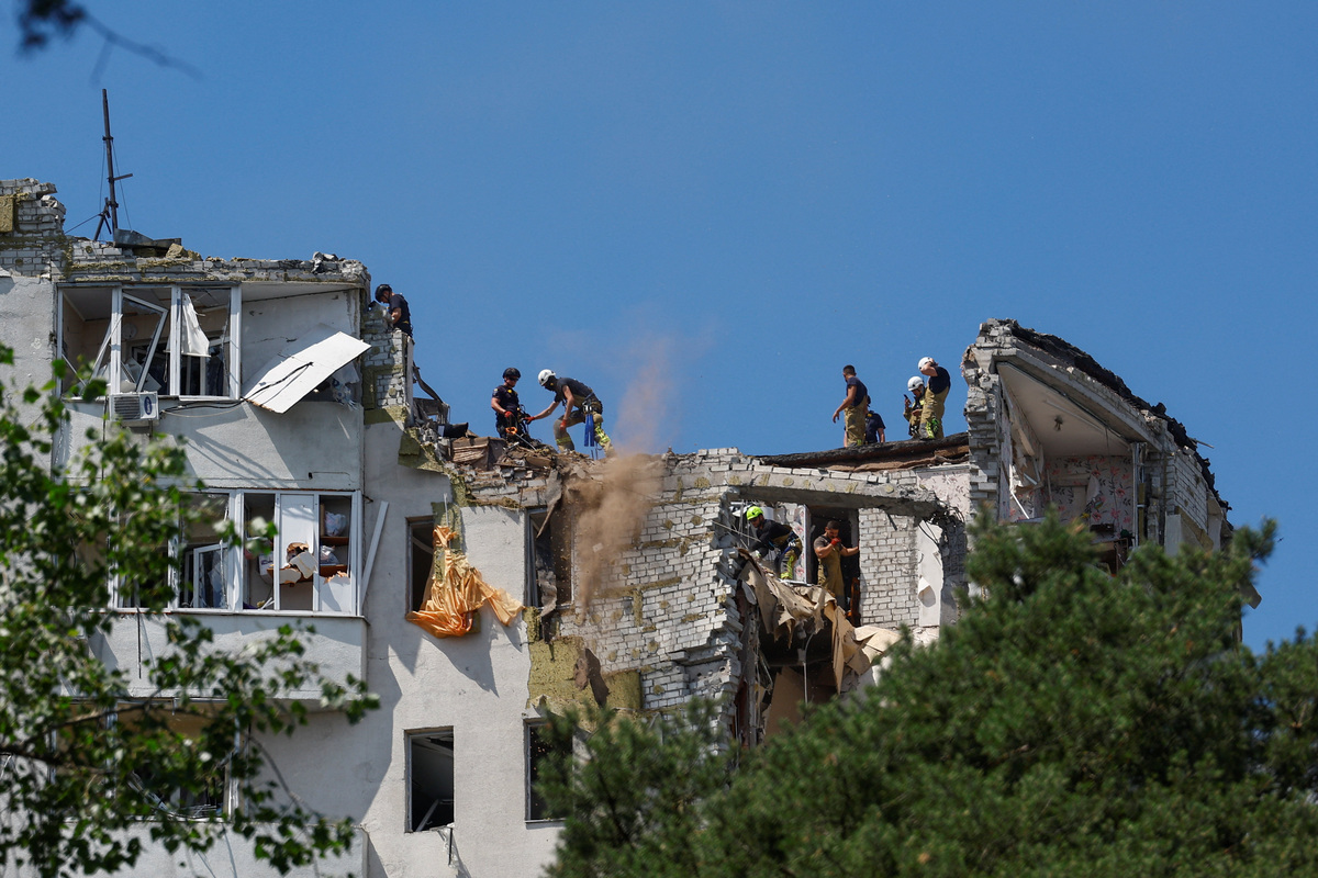 Rescuers work atop an apartment building damaged during overnight Russian missile and drone strikes, amid Russia's attack on Ukraine, in Kyiv, Ukraine, July 2, 2026. REUTERS/Valentyn Ogirenko