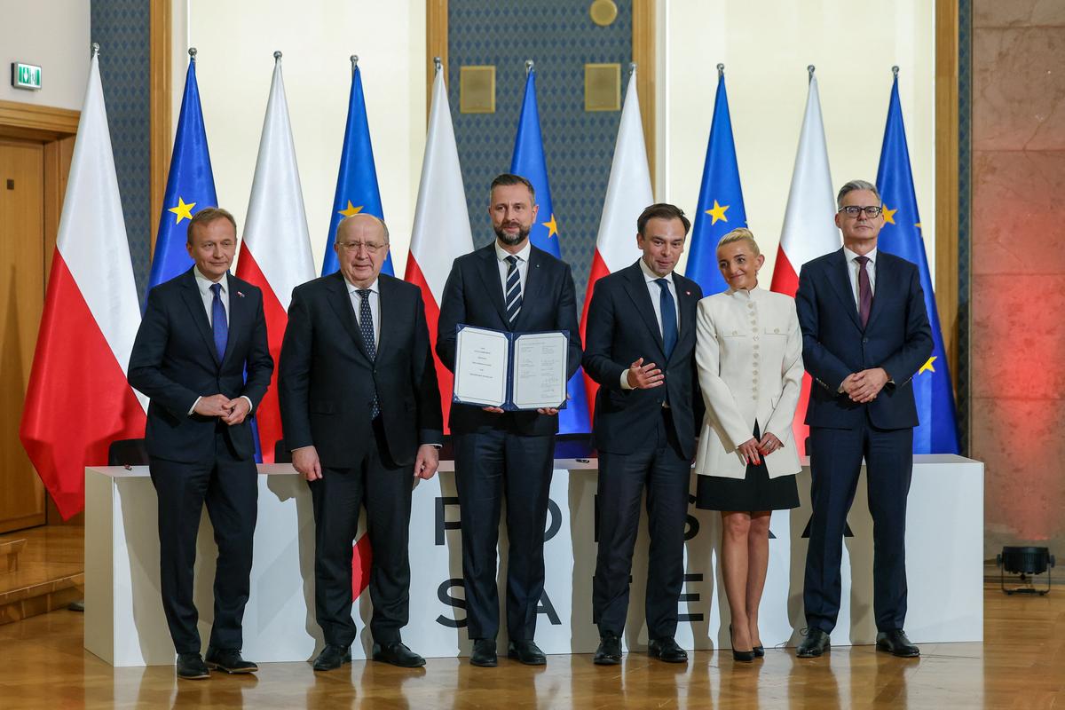 European Commissioner for Defence and Space Andrius Kubilius, European Commissioner for Budget, Anti-Fraud and Public Administration Piotr Serafin, Polish Deputy Prime Minister and Defence Minister Wladyslaw Kosiniak-Kamysz, Polish Finance Minister Andrzej Domanski, President of the National Development Bank (BGK) Miroslaw Czekaj and first Vice President of the management board of BGK Marta Postula pose following a signing ceremony for Poland's SAFE programme loan agreement, making it the first EU member state to sign the agreement, in Warsaw, Poland, May 8, 2026. REUTERS/Kacper Pempel