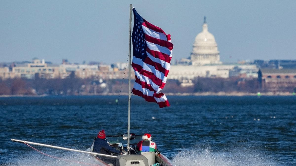 A boater flies an American flag on the Potomac River, with the U.S. Capitol visible in the background near Alexandria, Virginia, U.S., December 24, 2025. REUTERS/Ken Cedeno