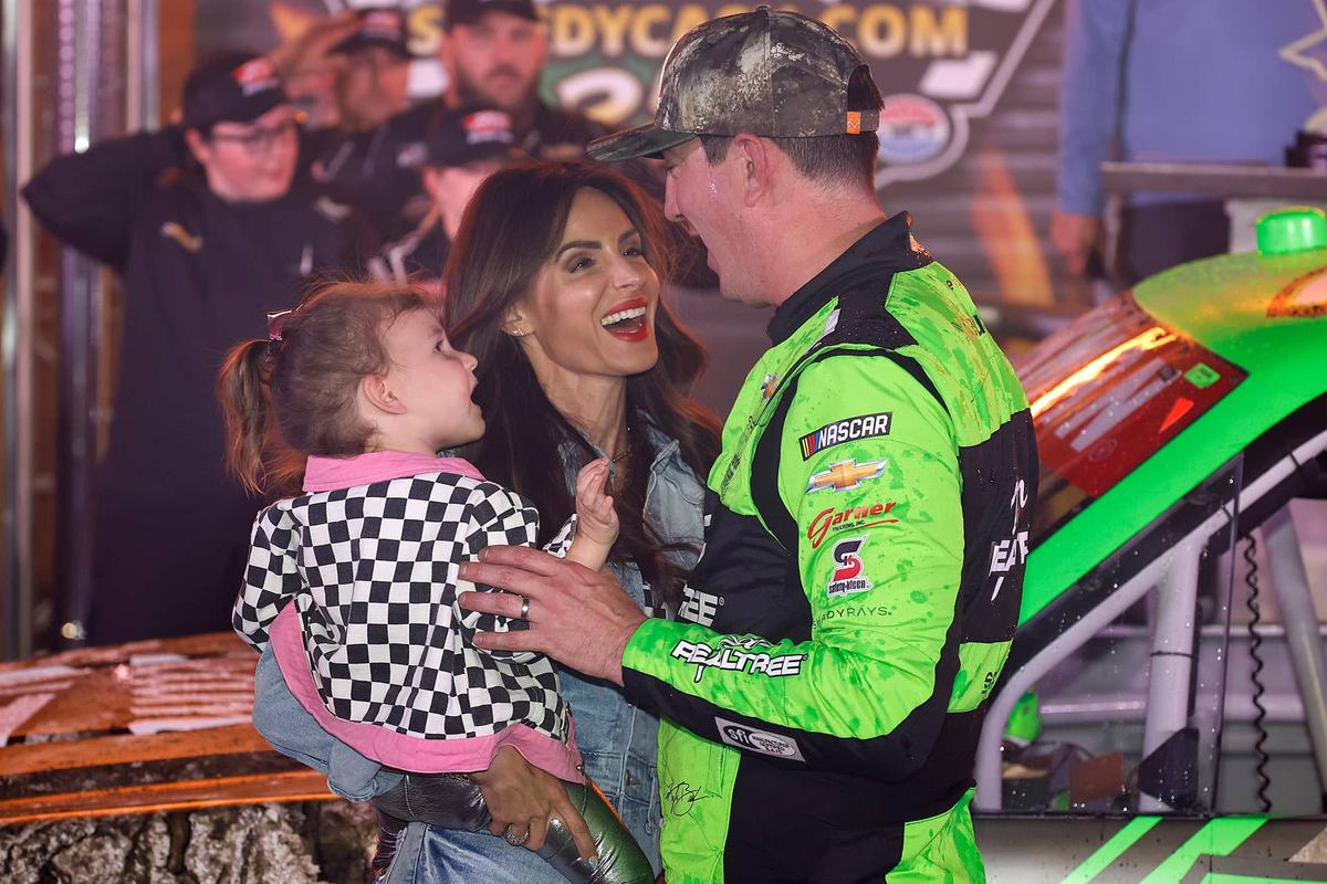  FORT WORTH, TEXAS - APRIL 12: Kyle Busch, driver of the #7 Realtree Chevrolet, celebrates with his wife, Samantha Busch, and daughter, Lennix Busch victory lane after winning the NASCAR Craftsman Truck Series SpeedyCash.com 250 at Texas Motor Speedway on April 12, 2024 in Fort Worth, Texas. (Photo by Chris Graythen/Getty Images) 