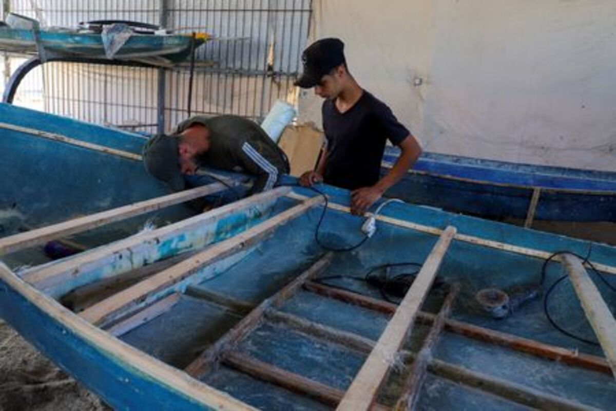 Palestinian workers repair a skiff damaged in the Israeli offensive, in Gaza City, June 3, 2026. REUTERS/Ebrahim Hajjaj