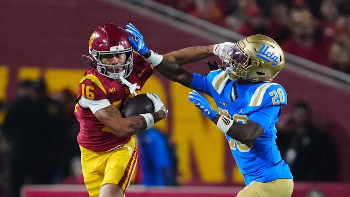  Nov 29, 2025; Los Angeles, California, USA; Southern California Trojans wide receiver Tanook Hines (16) carries the ball against UCLA Bruins defensive back Scooter Jackson (28) in the first half at United Airlines Field at Los Angeles Memorial Coliseum. Mandatory Credit: Kirby Lee-Imagn Images | Kirby Lee-Imagn Images 