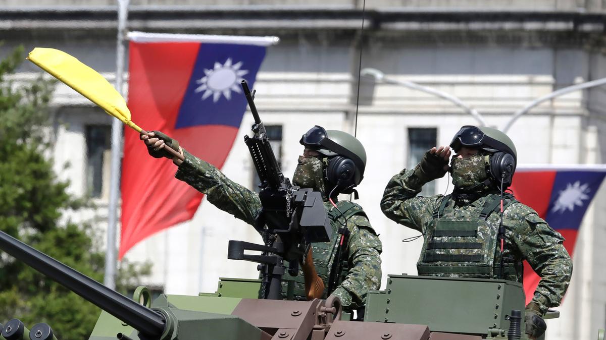 En esta imagen del 10 de octubre de 2021, soldados taiwaneses saludan durante las celebraciones por el Día Nacional frente al edificio presidencial, en Taipéi, Taiwán.