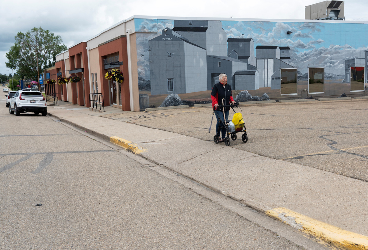 A woman walks down a street, where Alberta separatists set up an information booth nearby at the Ponoka Stampede, in Ponoka, Alberta, Canada, June 27, 2026.  REUTERS/Todd Korol