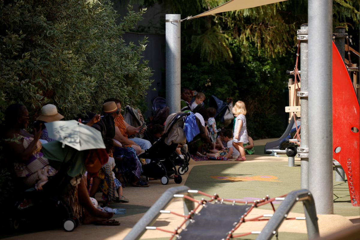 Parents and young children shelter in the shade at a children's playground in Paris as temperatures rise during a heatwave affecting a large part of France, June 22, 2026. REUTERS/Alice Sacco
