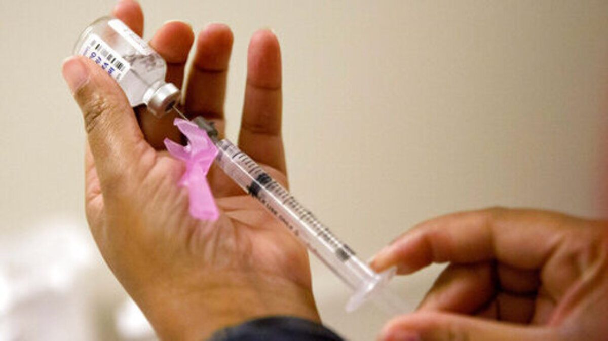 In this file photo, a nurse prepares a flu shot.
