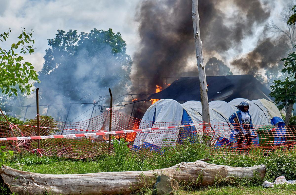 A Congolese police personnel stands guard at the burning Ebola treatment center, as aid agencies intensify efforts to contain a new Ebola outbreak involving the Bundibugyo strain outbreak, in Rwampara general hospital in Rwampara outside Bunia, Ituri province, Democratic Republic of Congo, May 21, 2026. REUTERS/Gradel Muyisa Mumbere