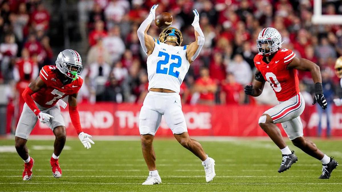  UCLA Bruins running back Anthony Frias II (22) bobbles the ball against Ohio State Buckeyes cornerback Jermaine Mathews Jr. (7) and linebacker Sonny Styles (0) in the second half of the NCAA college football game at Ohio Stadium on Saturday, Nov. 15, 2025 in Columbus, Ohio. | Samantha Madar/Columbus Dispatch / USA TODAY NETWORK via Imagn Images 
