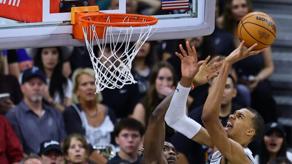 Victor Wembanyama (d), de los Spurs, lanza el balón en el segundo partido de las finales de la NBA entre San Antonio Spurs y New York Knicks en el estadio Frost Bank Center en San Antonio (Estados Unidos). EFE/ Carlos Ramírez