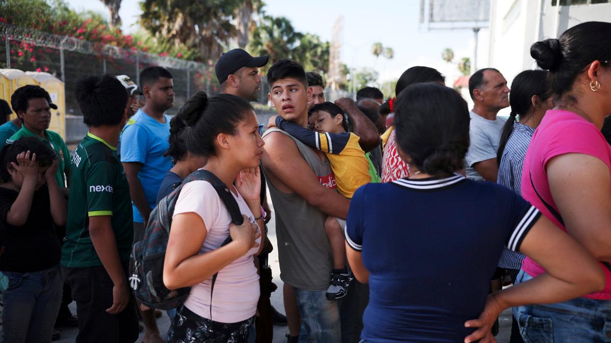 Solicitantes de asilo hacen fila en Matamoros, México, para recibir comida entregada por voluntarios de Estados Unidos, cerca del punto fronterizo con Brownsville, Texas, el 31 de julio de 2019. El gobierno de EEUU dijo el 5 de marzo de 2021 que podría reabrir algunos casos de solicitudes de asilo y que los solicitantes podrían entrar al país para esperar la resolución de sus casos.