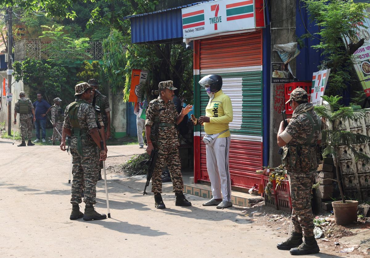 Members of security forces stop a delivery personnel as they stand guard along a road leading to the site where an aide of Suvendu Adhikari, a leader of Bharatiya Janata Party (BJP) in West Bengal state, was shot dead days after the BJP secured a majority in the state assembly elections, in North 24 Parganas, on the outskirts of Kolkata, India, May 7, 2026. REUTERS/Sahiba Chawdhary