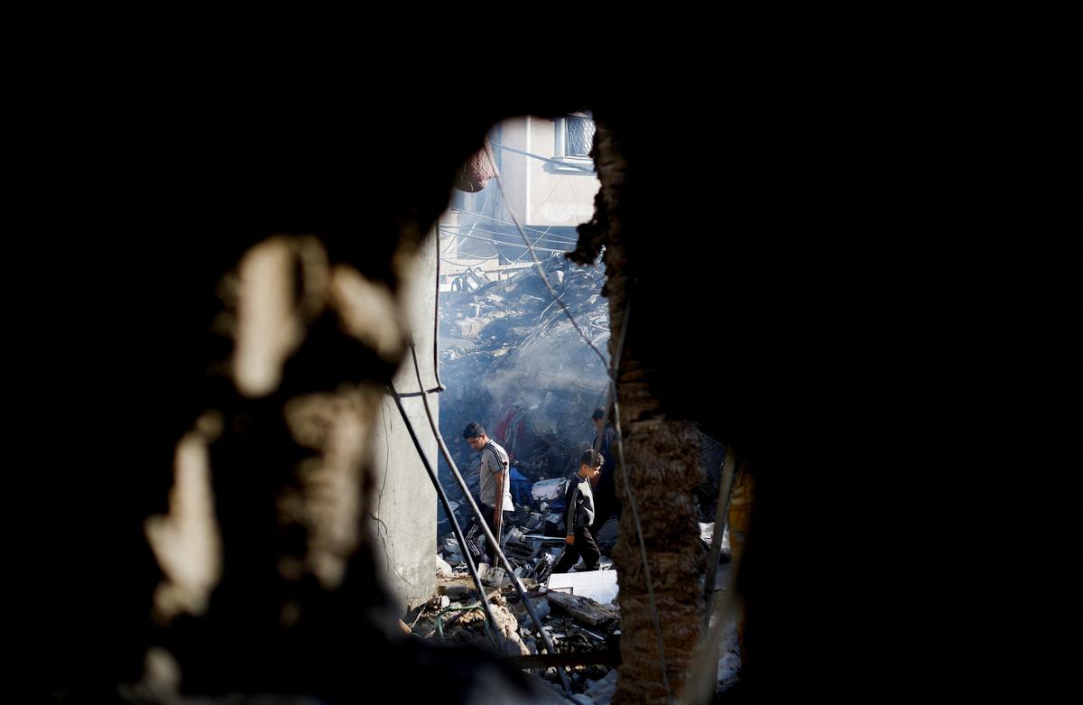 Palestinians inspect the site of an Israeli strike on a house that was pre-warned by the Israeli military to evacuate before the strike was carried out late on Saturday, in Deir al-Balah, in the central Gaza Strip, May 24, 2026. REUTERS/Mahmoud Issa