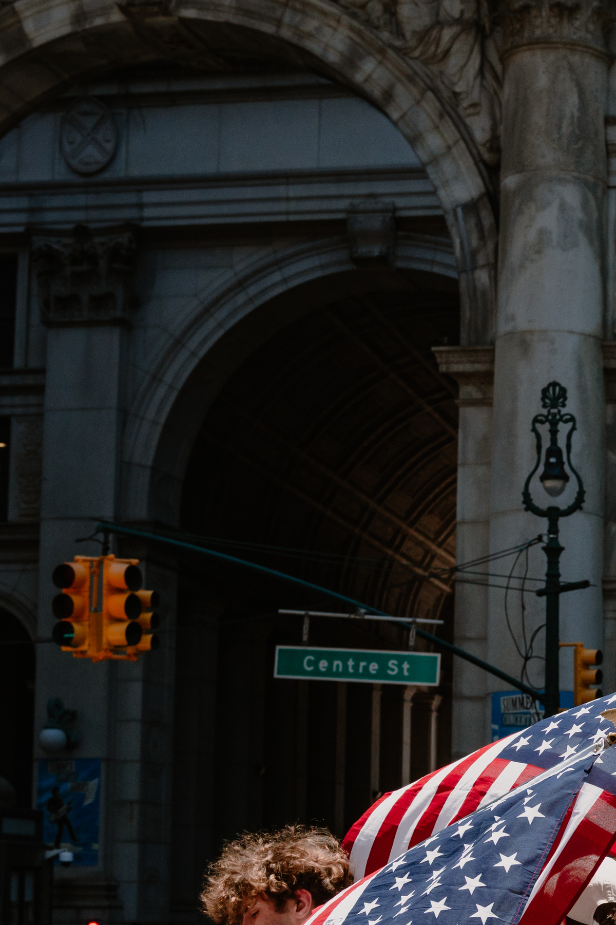A group of teenagers carrying large American flags walks past City Hall in Lower Manhattan on July 4, 2026. Though it was muggy and miserably hot in many parts of the country, the day was marked with the usual American exuberance, with fighter jets, tall ships, parachutists and flag-festooned pick-up trucks. (Lucia Vazquez/The New York Times)