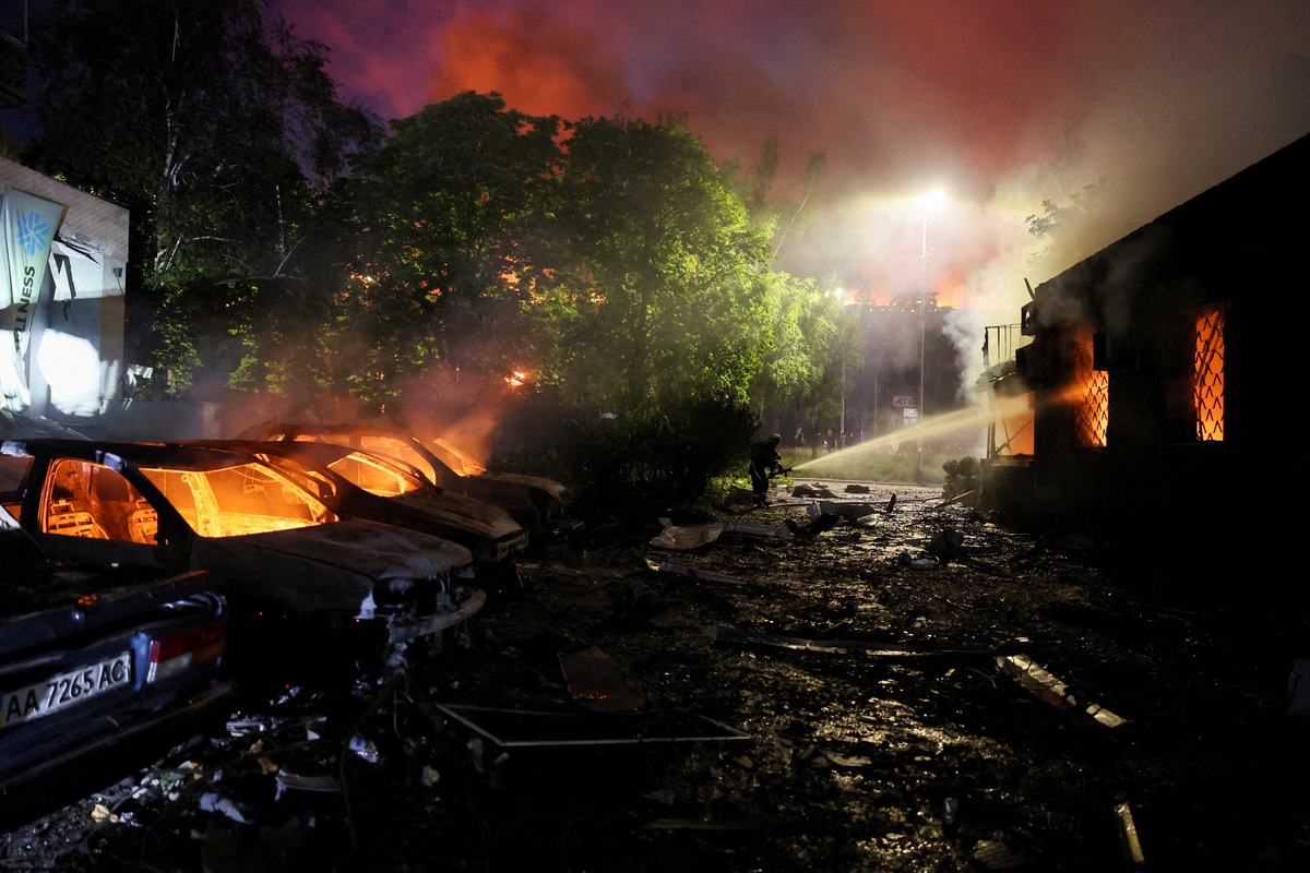 A firefighter works near burning cars, at the site of an apartment building damaged during Russian missile strikes, amid Russia’s attack on Ukraine, in Kyiv, Ukraine July 19, 2026. REUTERS/Gleb Garanich
