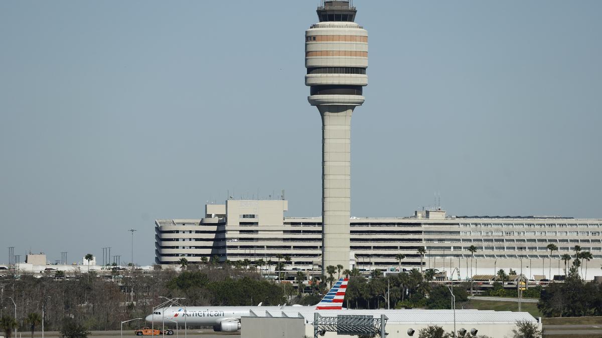 An American Airlines aircraft moves past the air traffic control tower at the Orlando International Airport, on Jan. 27, 2026. (Ricardo Ramirez Buxeda/Orlando Sentinel/TNS)