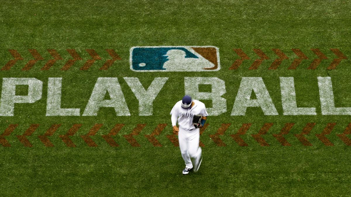 FILE - Padres left fielder Allen Cordoba passes a logo for Play Ball, an initiative from Major League Baseball and USA Baseball, during a game against the Colorado Rockies on June 3, 2017, in San Diego.