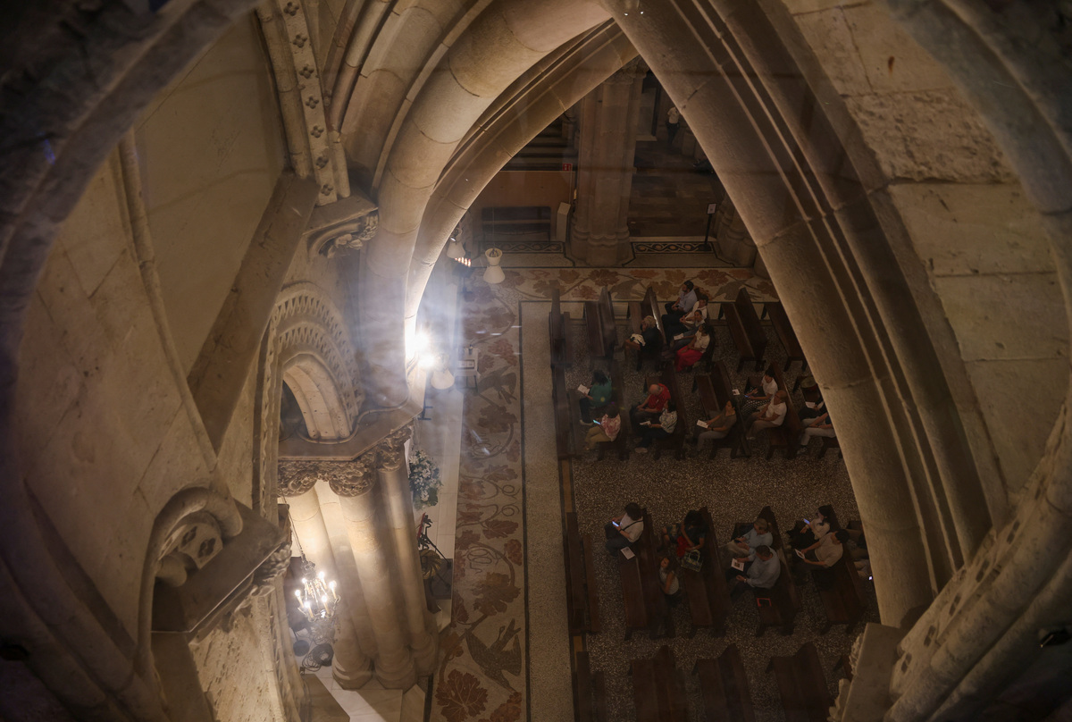 Tourists and locals pray inside the Chapel of Our Lady of Mount Carmel of the Sagrada Familia basilica, designed by Catalan architect Antoni Gaudi, who is buried there, ahead of Pope Leo XIV's visit to Barcelona, Spain, June 3, 2026.  REUTERS/Nacho Doce