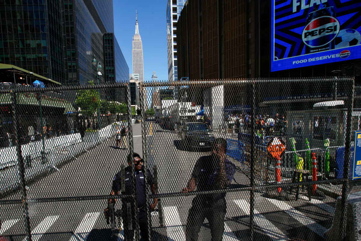 Security workers stand guard next to a security fence as people walk outside of Madison Square Garden ahead of Game three of the NBA Finals between the New York Knicks and San Antonio Spurs at Madison Square Garden in New York City, U.S., June 8, 2026.  REUTERS/Eduardo Munoz