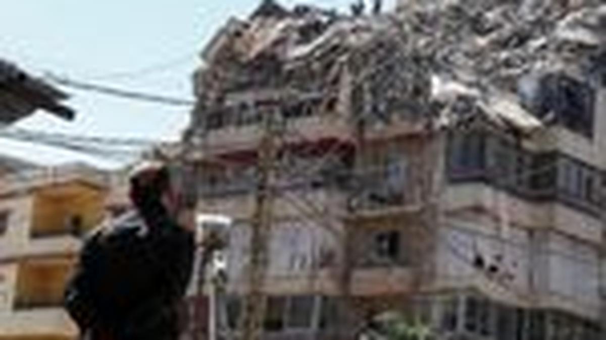 A man watches as rescuers work at the site of an Israeli strike that took place yesterday, in the southern suburbs of Beirut, Lebanon, May 7, 2026. REUTERS/Mohamad Azakir