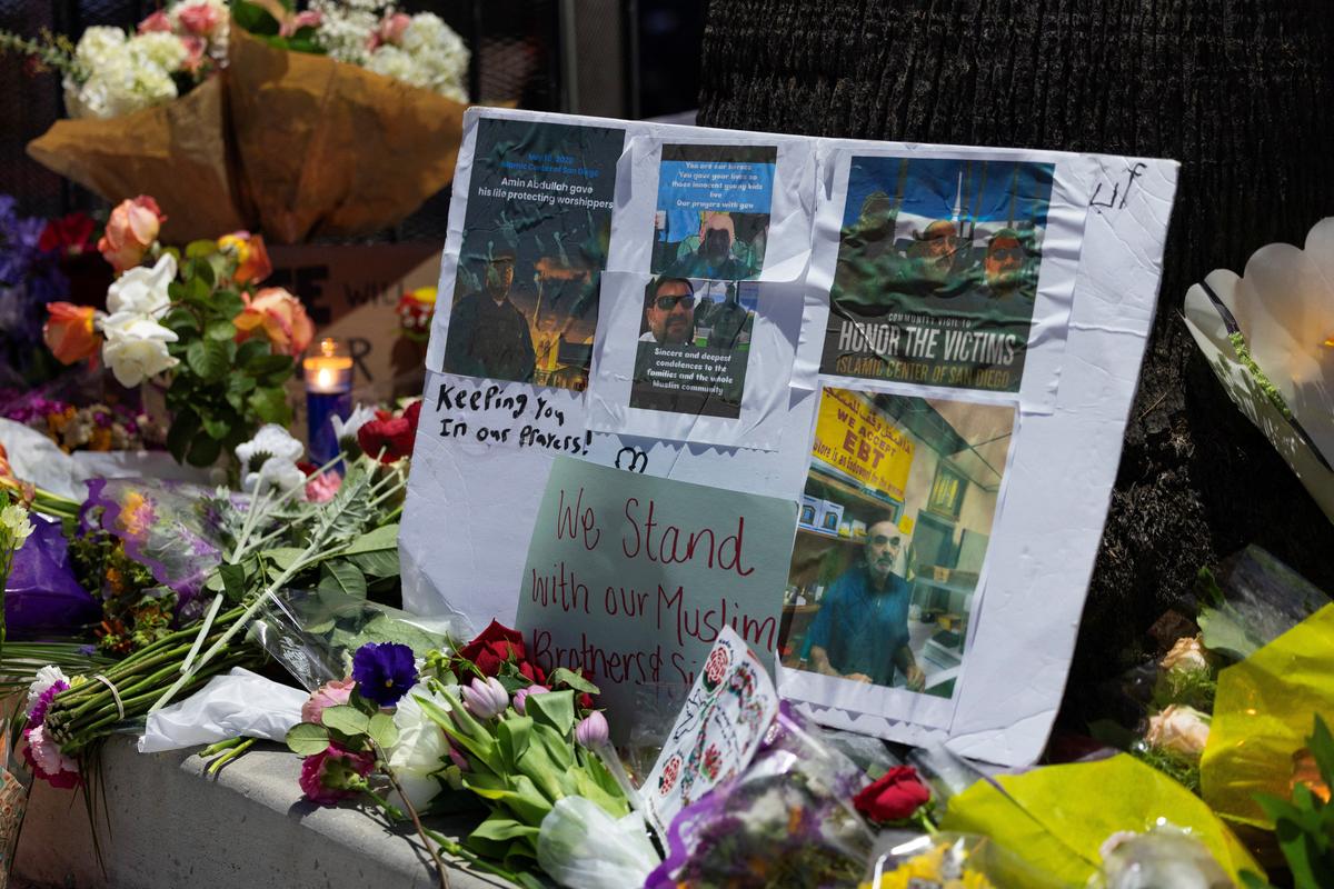 Flowers and signs are kept at a memorial outside the Islamic Center of San Diego as the center opens for early morning call to prayer for the first time following a shooting in San Diego, California, U.S., May 20, 2026. REUTERS/Mike Blake