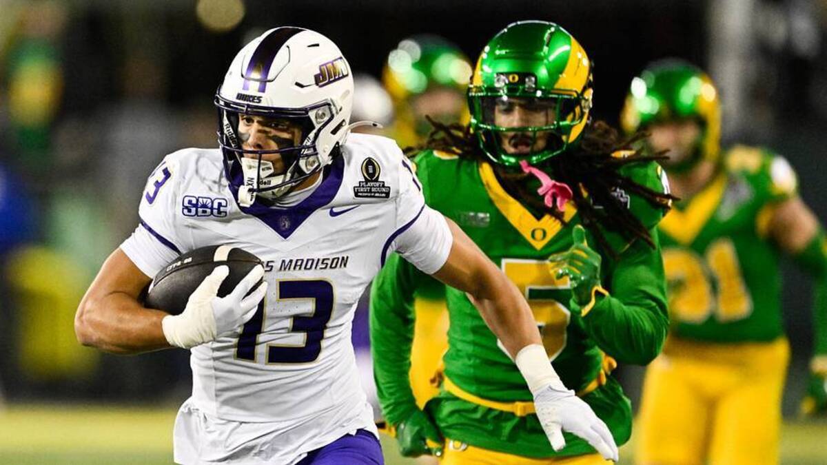  Dec 20, 2025; Eugene, OR, USA; James Madison Dukes wide receiver Landon Ellis (13) runs after making a catch as Oregon Ducks defensive back Theran Johnson (5) defends during the second quarter at Autzen Stadium. Mandatory Credit: Troy Wayrynen-Imagn Images | Troy Wayrynen-Imagn Images 