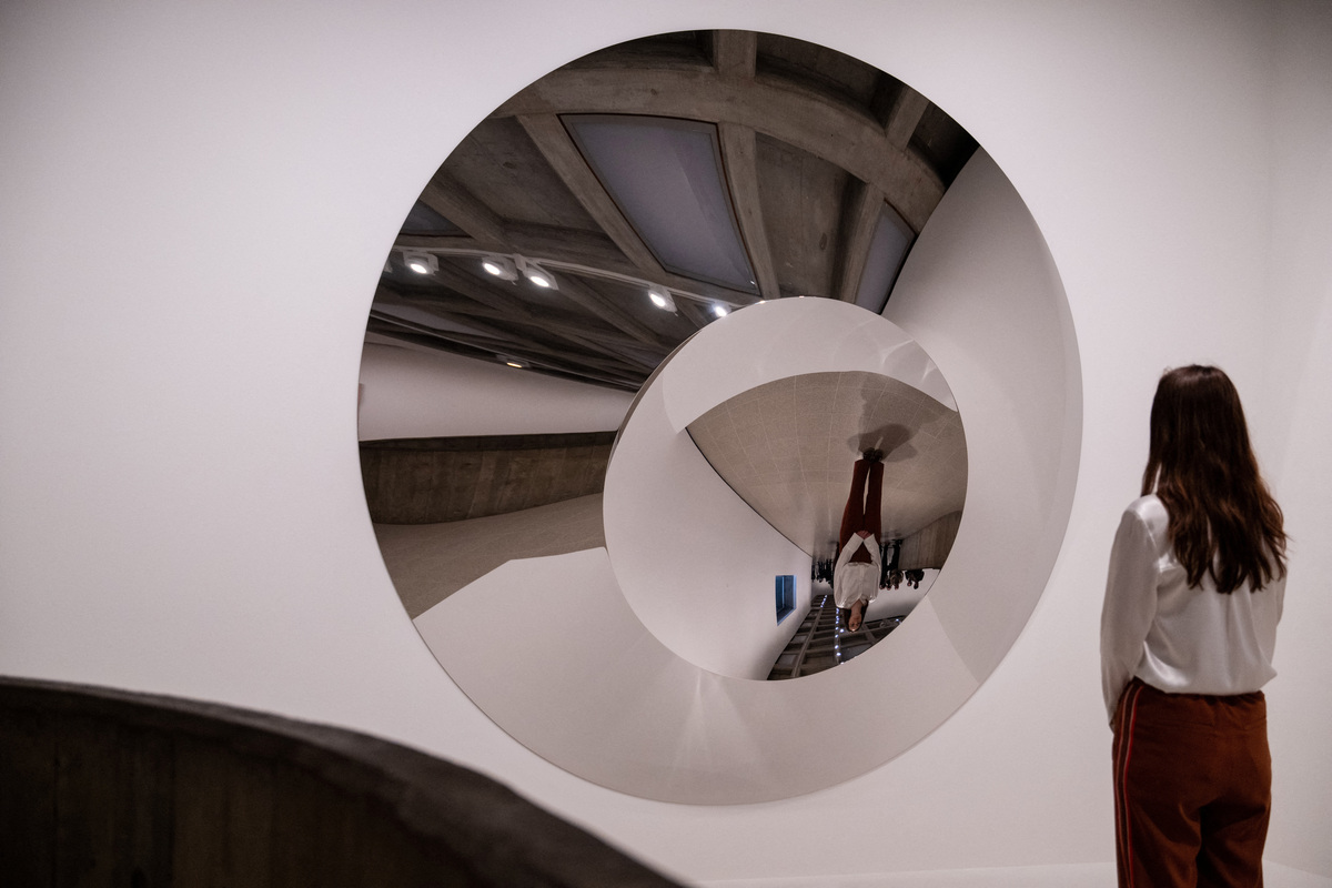 A gallery assistant poses for a photographs next to Anish Kapoor's installation 'Untitled' (2026) during the press view for 'Anish Kapoor' at the Hayward Gallery, in London, Britain, June 15, 2026. REUTERS/Chris J. Ratcliffe