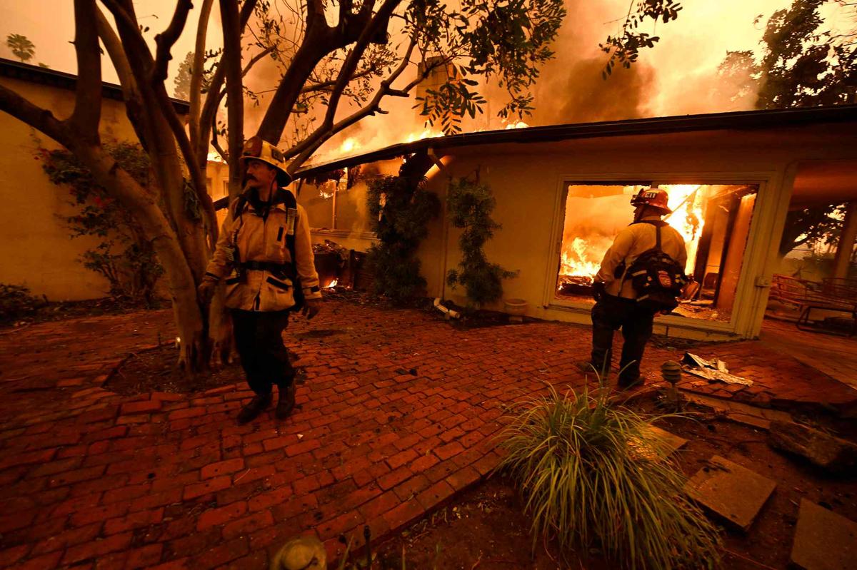 Firefighters check on a burning home during the Eaton fire in the Hastings Ranch community of Pasadena early Wednesday morning Jan. 8, 2025. At least 30 homes have been lost to the fire in the area over night. (Photo by Will Lester, Inland Valley Daily Bulletin/SCNG)