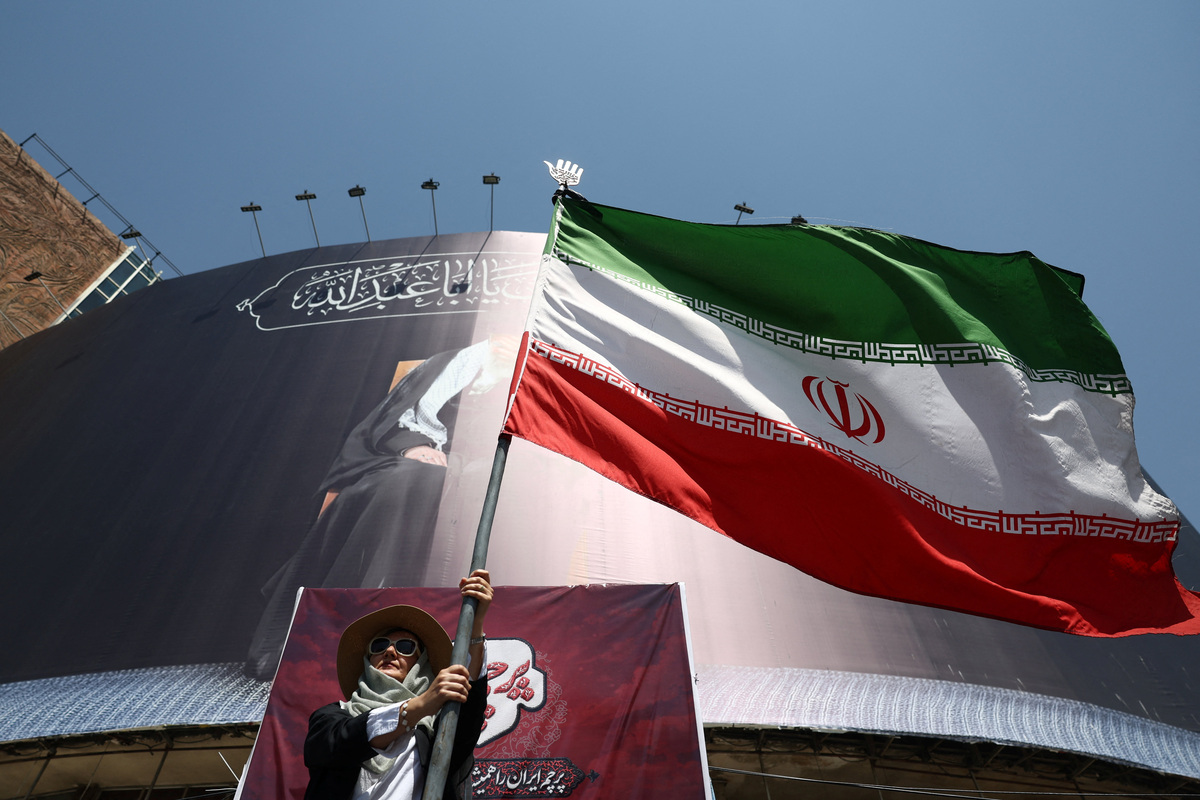 A woman holds an Iranian flag on a street in Tehran, Iran, June 30, 2026. Majid Asgaripour/WANA (West Asia News Agency) via REUTERS