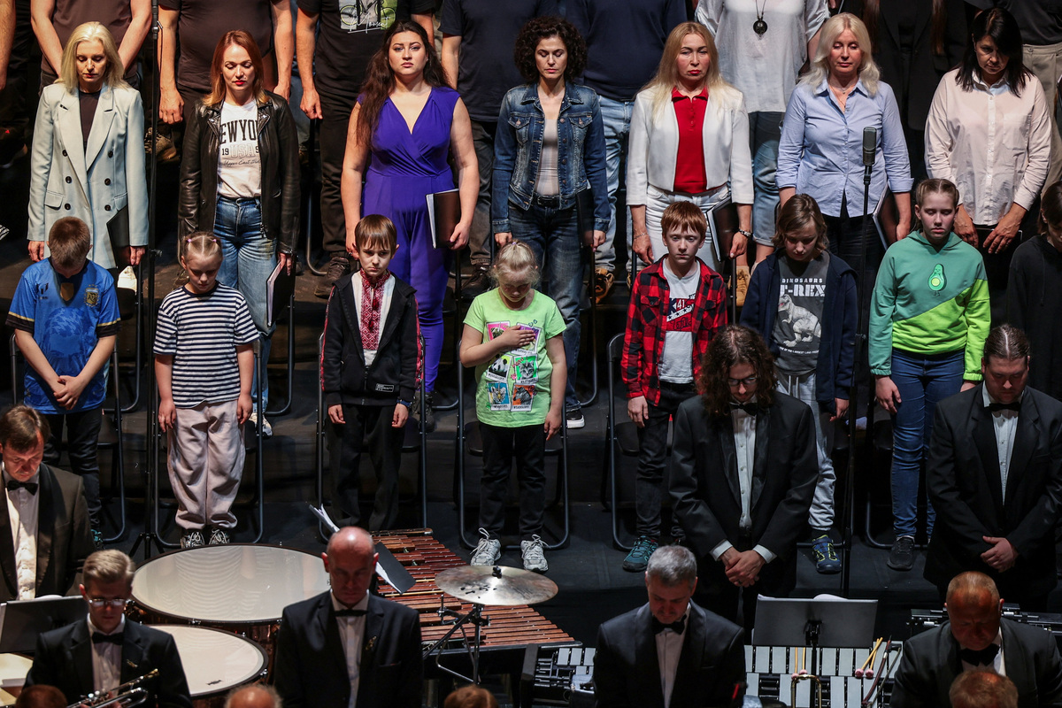 Choir members and musicians pay tribute to children killed in the war during a moment of silence before the premiere of the contemporary opera "Mothers of Kherson", which tells the story of Ukrainian mothers seeking to recover children abducted by Russia, co-commissioned by Metropolitan Opera in New York and the Polish National Opera in Warsaw, amid Russia’s attack on Ukraine, at the Taras Shevchenko National Opera and Ballet Theatre in Kyiv, Ukraine, June 4, 2026. REUTERS/Alina Smutko