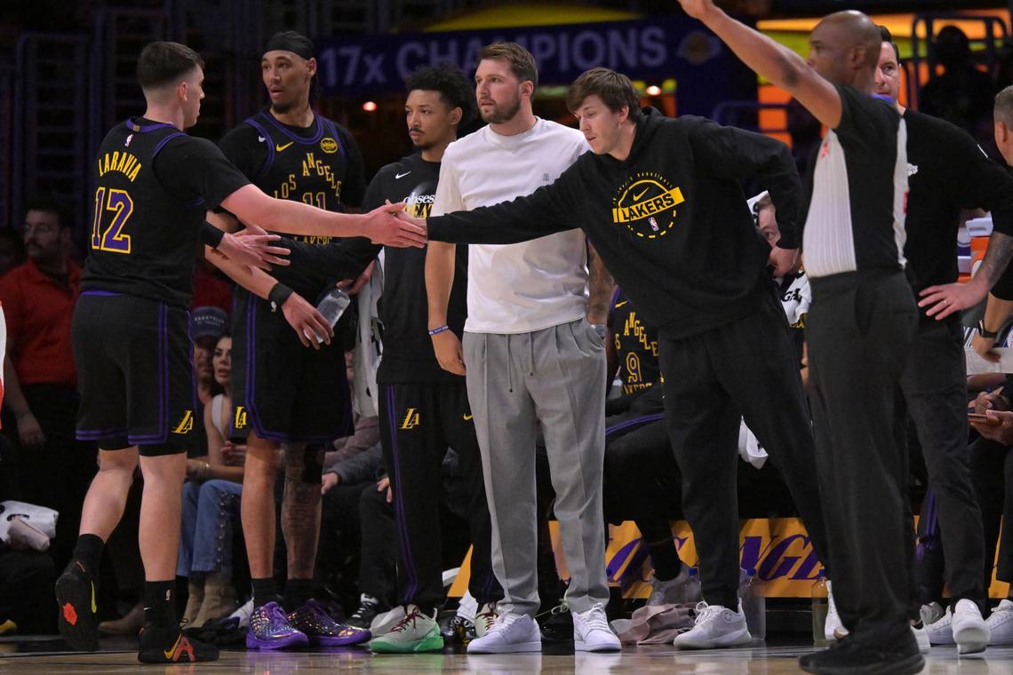  Los Angeles Lakers guard Austin Reaves greets forward Jake LaRavia as guard Luka Dončić looks on during a playoff game against the Houston Rockets at Crypto.com Arena on April 21, 2026. Jayne Kamin-Oncea-Imagn Images