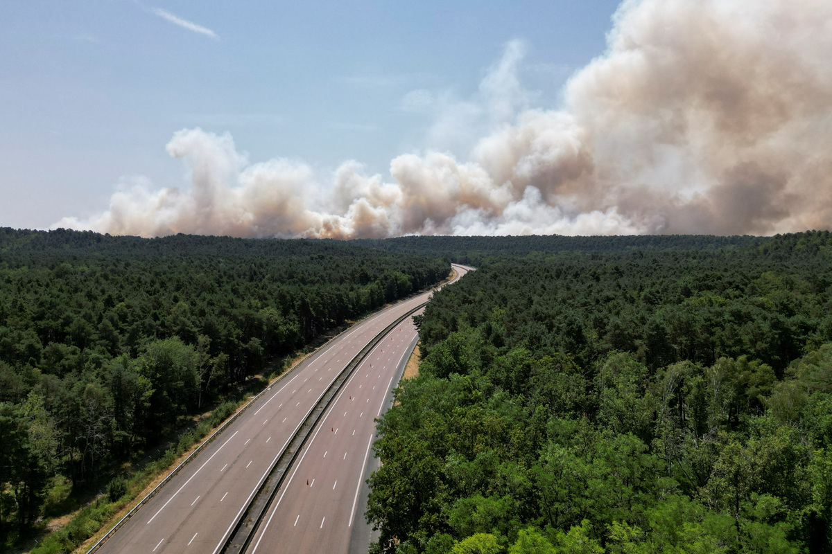 A drone view of plumes of smoke billowing over the empty A6 highway, as French firefighters battle a wildfire in the Fontainebleau forest in Noisy-sur-Ecole near Paris, amid a heatwave affecting a large part of the country, France, July 13, 2026. REUTERS/Benoit Tessier