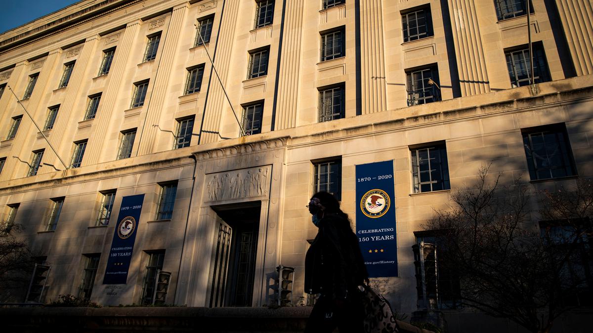 A woman walks past the U.S. Department of Justice Building, in Washington, U.S., December 15, 2020. REUTERS/Al Drago