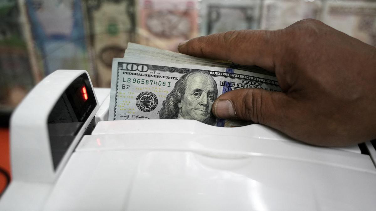 A person uses a counting machine to counts U.S. dollar bills at a currency exchange house in Bogota, Colombia, June 10, 2025. REUTERS/Nathalia Angarita