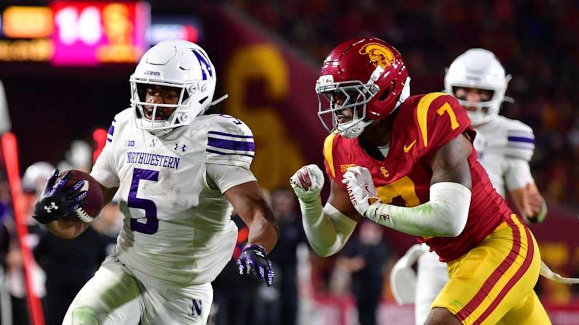  Nov 7, 2025; Los Angeles, California, USA; Northwestern Wildcats running back Caleb Komolafe (5) runs the ball against Southern California Trojans safety Kamari Ramsey (7) during the first half at the Los Angeles Memorial Coliseum. Mandatory Credit: Gary A. Vasquez-Imagn Images | Gary A. Vasquez-Imagn Images 
