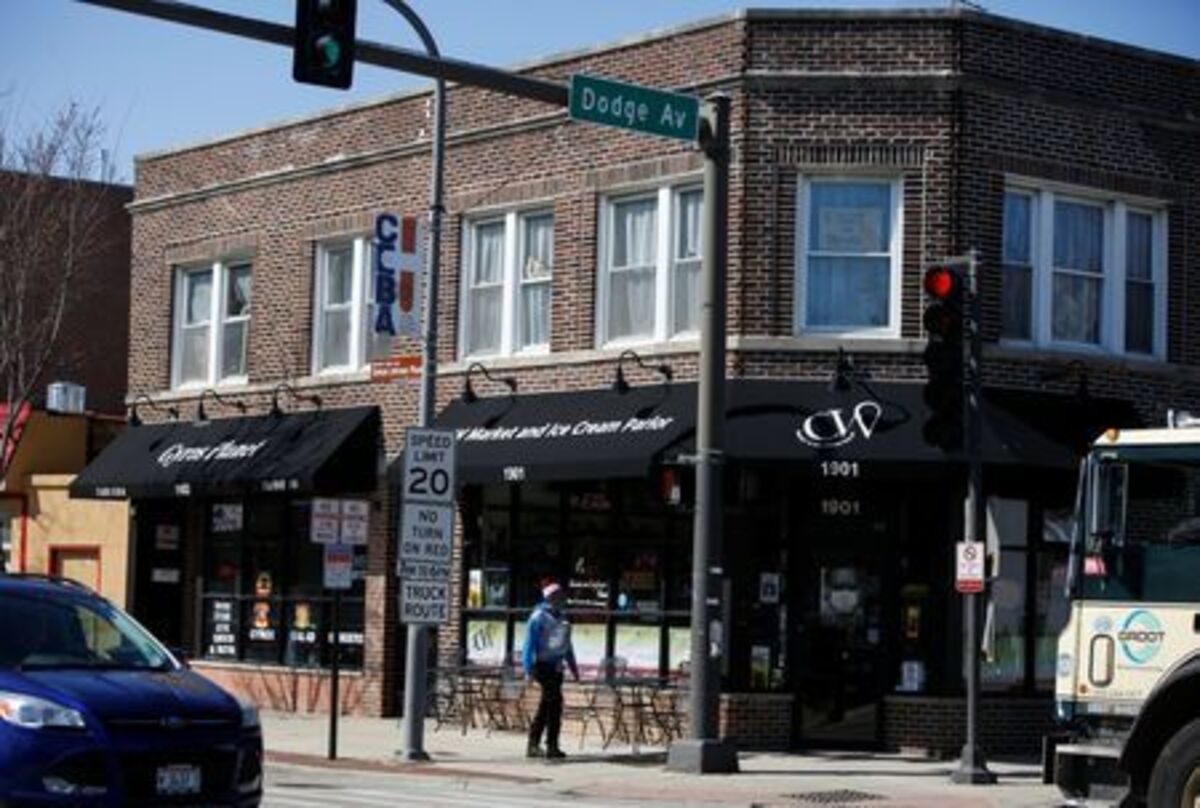 A woman walks past a local market on the corner of Church Street and Dodge Avenue in the Fifth Ward, known as the historic Black community, in Evanston, Illinois, U.S March 19, 2021. REUTERS/Eileen T. Meslar