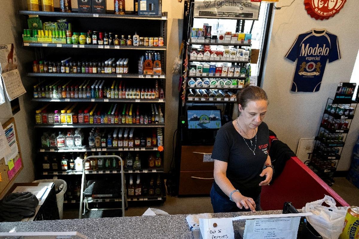 Tonyah Bruyette checks out a customer at the liquor store where she works in Wiggins, Colorado, U.S., May 11, 2026.  REUTERS/Kevin Mohatt