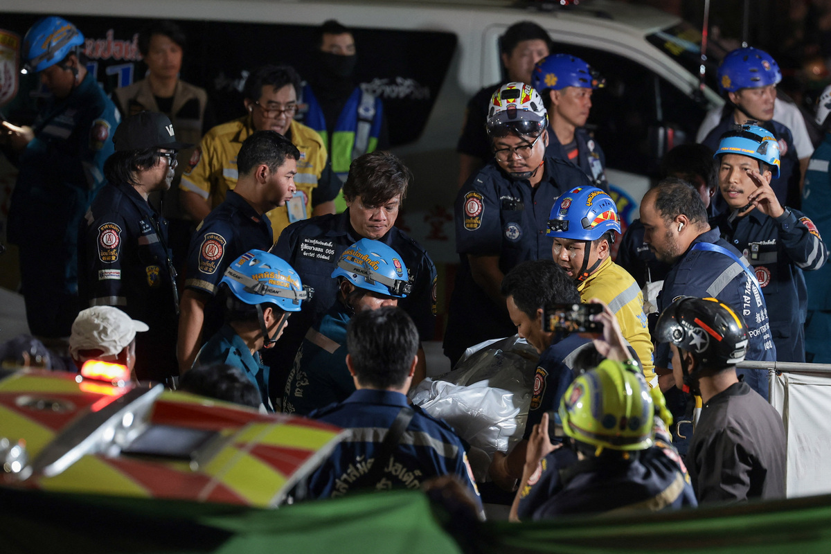 Members of emergency personnel transfer the body of a deceased person at the site of a deadly fire at a pub in Bangkok, Thailand, July 13, 2026. REUTERS/Chalinee Thirasupa
