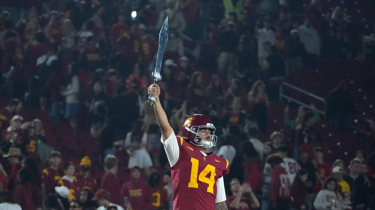  Nov 29, 2025; Los Angeles, California, USA; Southern California Trojans quarterback Jayden Maiava (14) leads the Spirit of Troy marching band in a rendition of Tribute to Troy after teh game against the UCLA Bruins at United Airlines Field at Los Angeles Memorial Coliseum. Mandatory Credit: Kirby Lee-Imagn Images | Kirby Lee-Imagn Images 