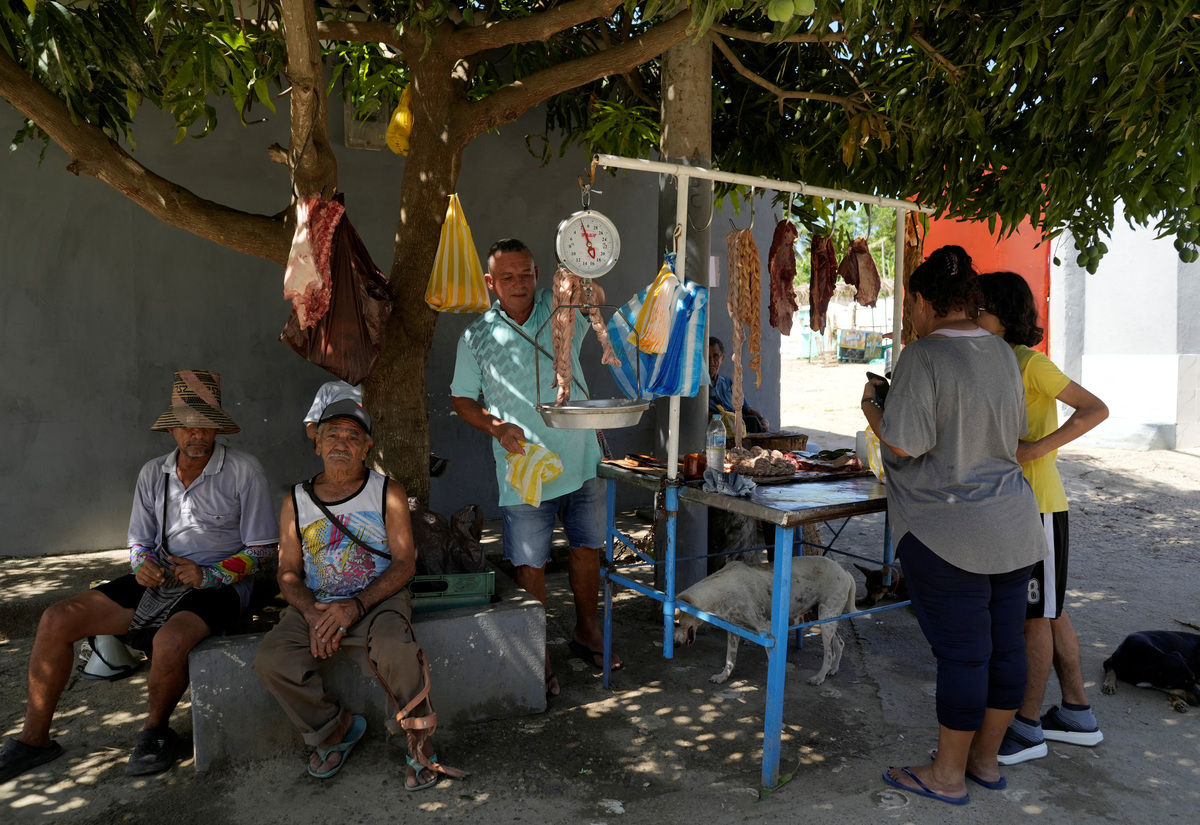 Butcher Nicanor Alba serves clients ahead of the 21 June runoff between right-wing presidential candidate Abelardo De La Espriella and leftist candidate Ivan Cepeda, in Juan de Acosta, Colombia, June 11, 2026. REUTERS/Charlie Cordero