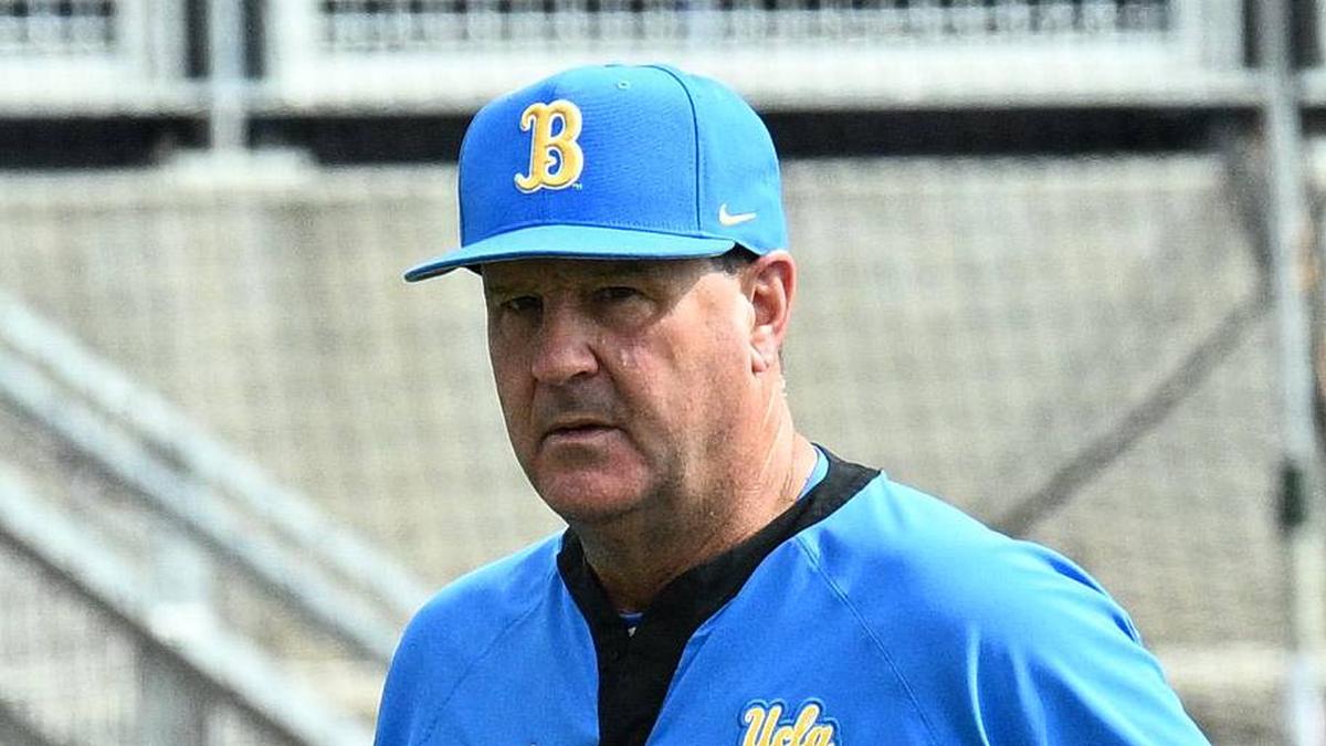  Jun 17, 2025; Omaha, Neb, USA; UCLA Bruins head coach John Savage (22) walks to the dugout before the restart of the game against the LSU Tigers at Charles Schwab Field. Mandatory Credit: Steven Branscombe-Imagn Images | Steven Branscombe-Imagn Images 