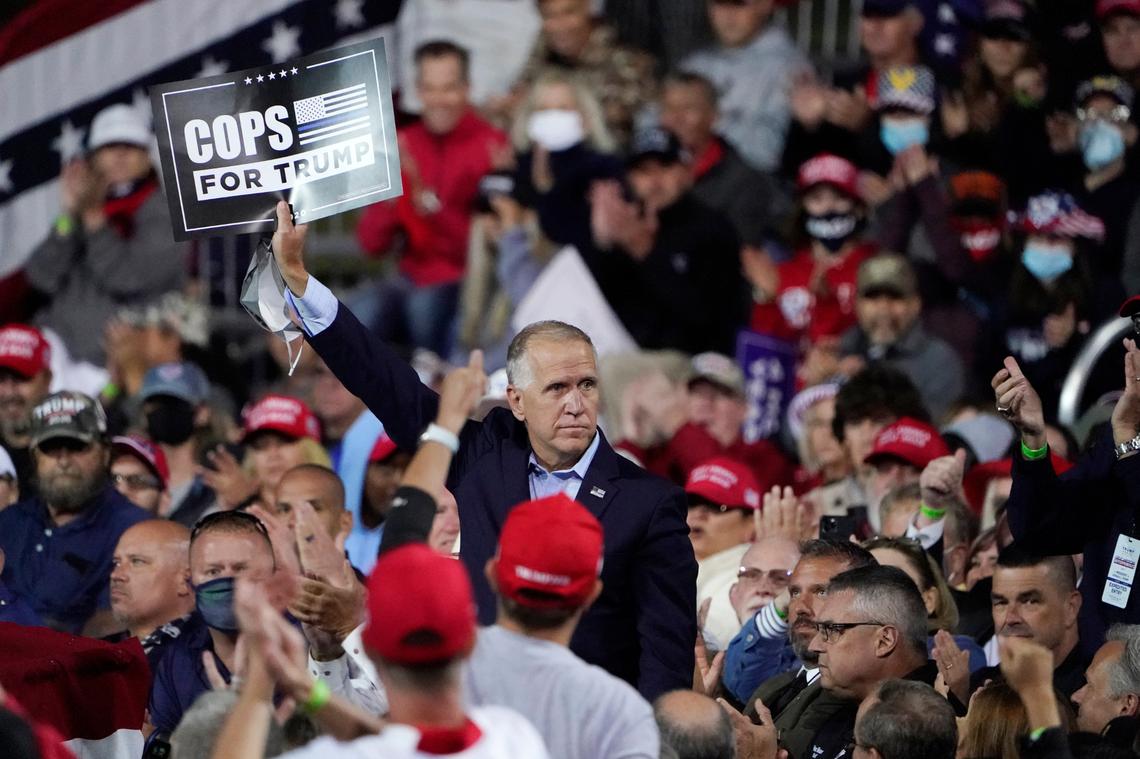 FILE - In this Sept. 19, 2020 file photo, Sen. Tom Tillis, R-N.C. holds a sign as President Donald Trump speaks at a campaign rally at the Fayetteville Regional Airport in Fayetteville, N.C. North Carolina Democrats were hoping this November they would break the backs of Republicans, who, after dominating state politics for much of the past decade, saw their power erode in the 2016 and 2018 elections. Instead, state Democrats had little to tout after Election Day beyond Gov. Roy Cooper’s close yet expected reelection, a narrow victory for Attorney General Josh Stein, and picking up two U.S. House seats largely handed to them by redistricting in 2019. (AP Photo/Chris Carlson, File)