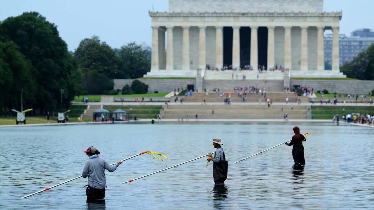 Park Service employees use vacuums to remove green algae from the bottom of the Lincoln Memorial Reflecting Pool.