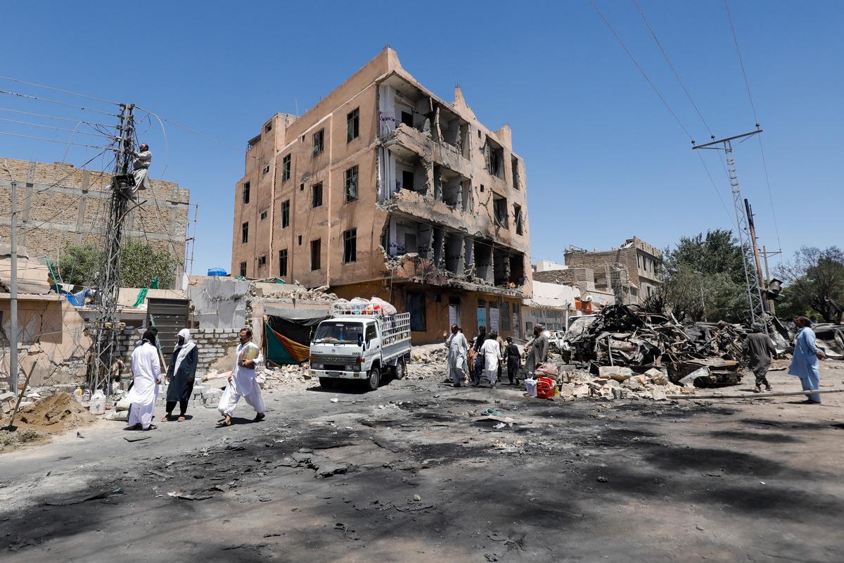 Residents walk past a damaged building, rubble and destroyed cars a day after a blast in Quetta, Pakistan May 25, 2026. REUTERS/Naseer Ahmed