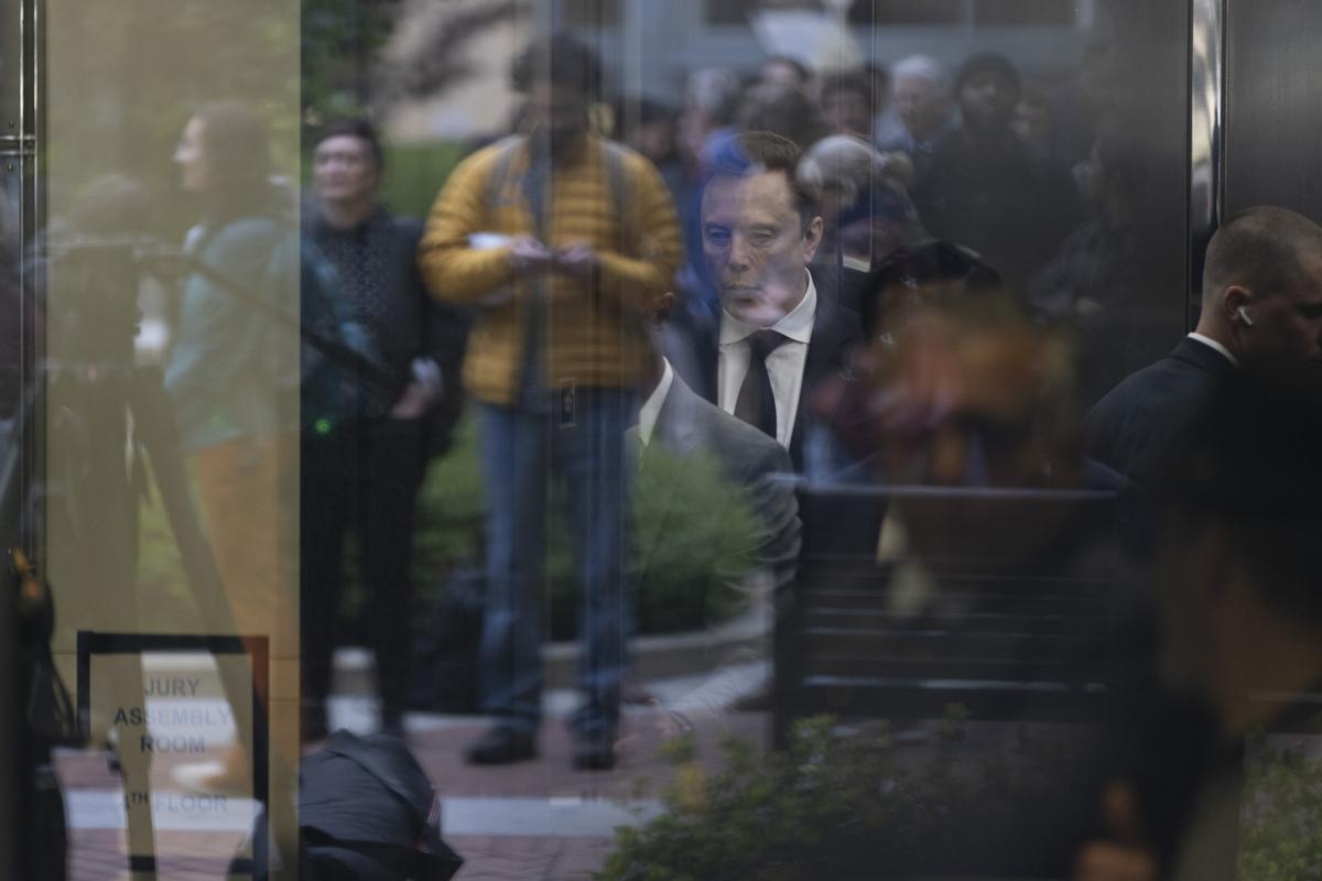 **EDS: RETRANSMISSION OF XNYT0174, MUSK OPENAI TRIAL 4, SENT ON APRIL 28, 2026 TO CORRECT DATE AND TO CORRECT BYLINE TO BRENNAN SMART** Seen through reflections in glass, Elon Musk arrives at The Ronald V. Dellums Federal Courthouse in Oakland, Calif., the venue for his lawsuit against OpenAI, on Tuesday, April 28, 2026. The blockbuster trial could reshape one of the artificial intelligence industry's most important companies and shift the course of the AI race. (Brennan Smart/The New York Times)