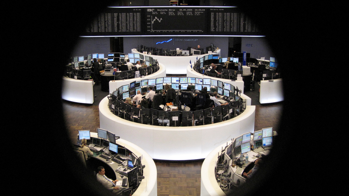FILE PHOTO: Traders work at their desks in front of the DAX board at the Frankfurt stock exchange May 8, 2009. REUTERS/Remote/Pawel Kopczynski/File Photo
