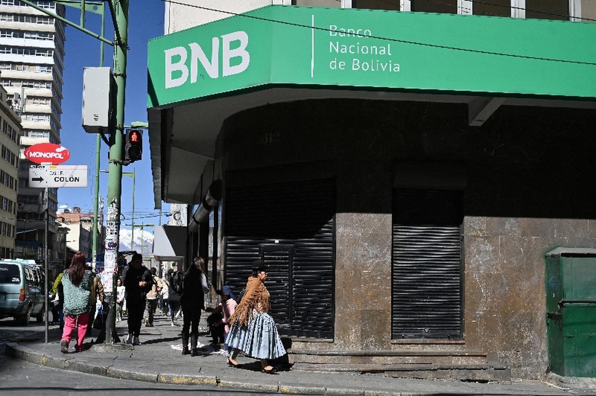 People walk past a closed branch of the National Bank of Bolivia (BNB), as several Bolivian banks temporarily closed branches due to ongoing unrest driven by anti-government demonstrations, in La Paz, Bolivia, May 19, 2026. REUTERS/Claudia Morales