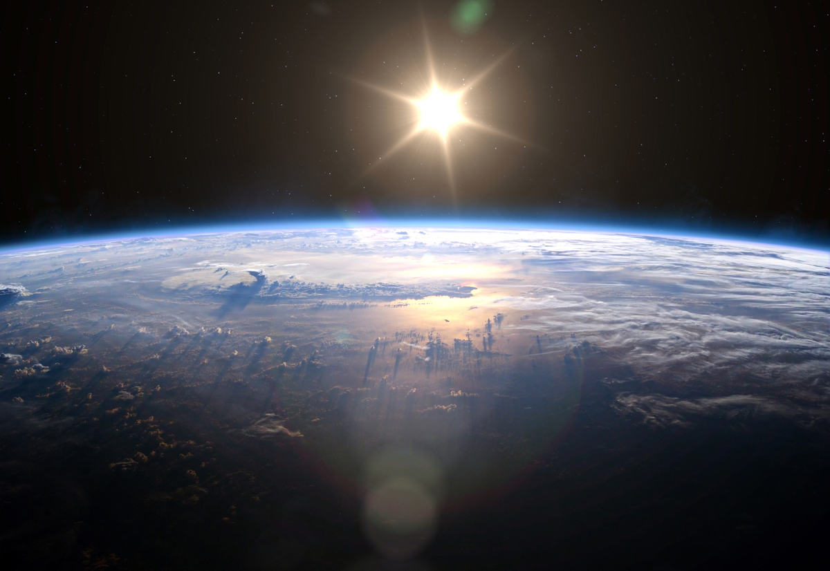  An image shows Earth and the sun in space. The FCC has approved a test satellite to reflect sunlight back to Earth. 