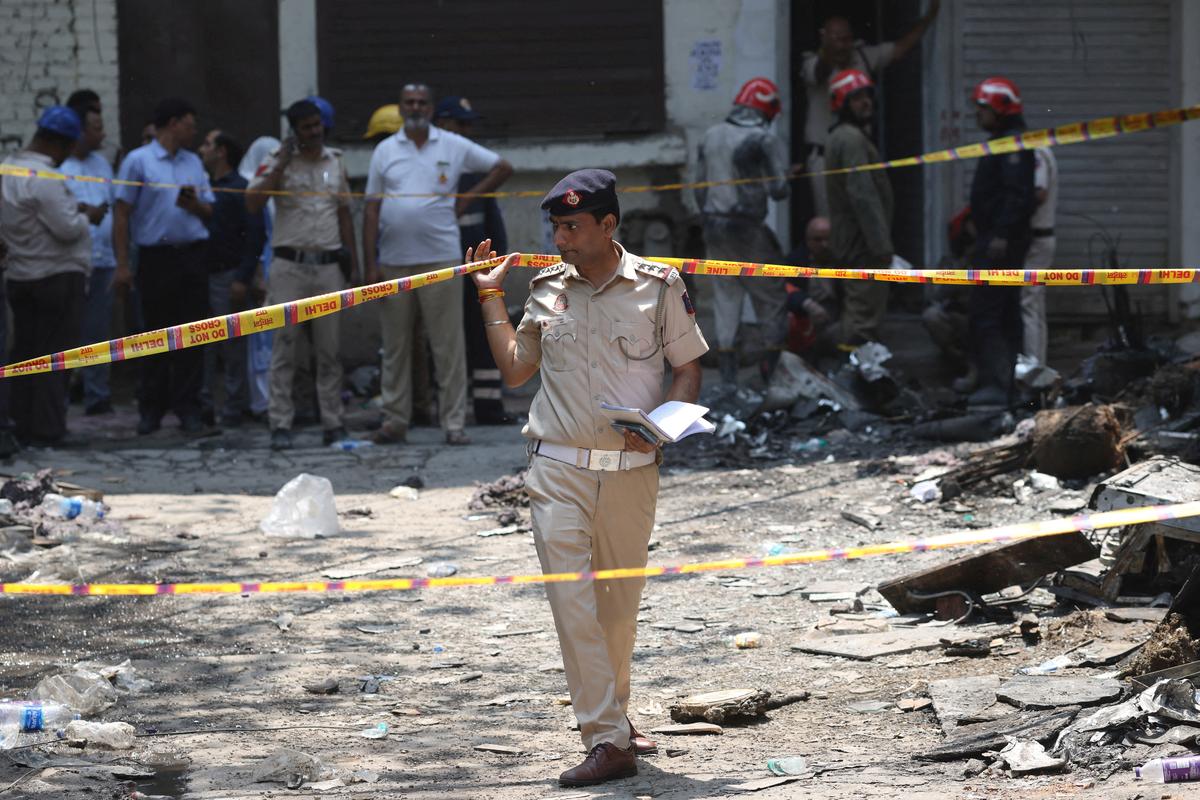 A police officer walks in-between security tapes at the spot after a fire at a hotel in New Delhi, India, June 3, 2026. REUTERS/Adnan Abidi