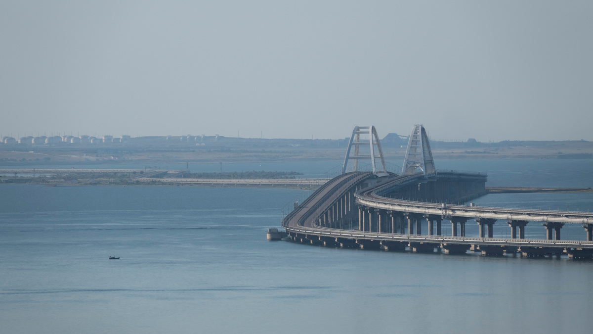 A boat sails next to the Crimean bridge connecting the Russian mainland with the peninsula across the Kerch Strait, Crimea, July 17, 2023.  REUTERS/Stringer